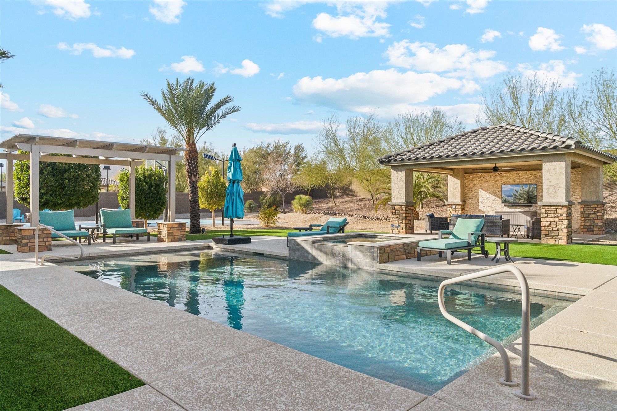 Luxury Arizona short-term rental with resort-style pool, covered patio lounge, and upscale outdoor furnishings designed to elevate guest experience and boost vacation rental bookings.