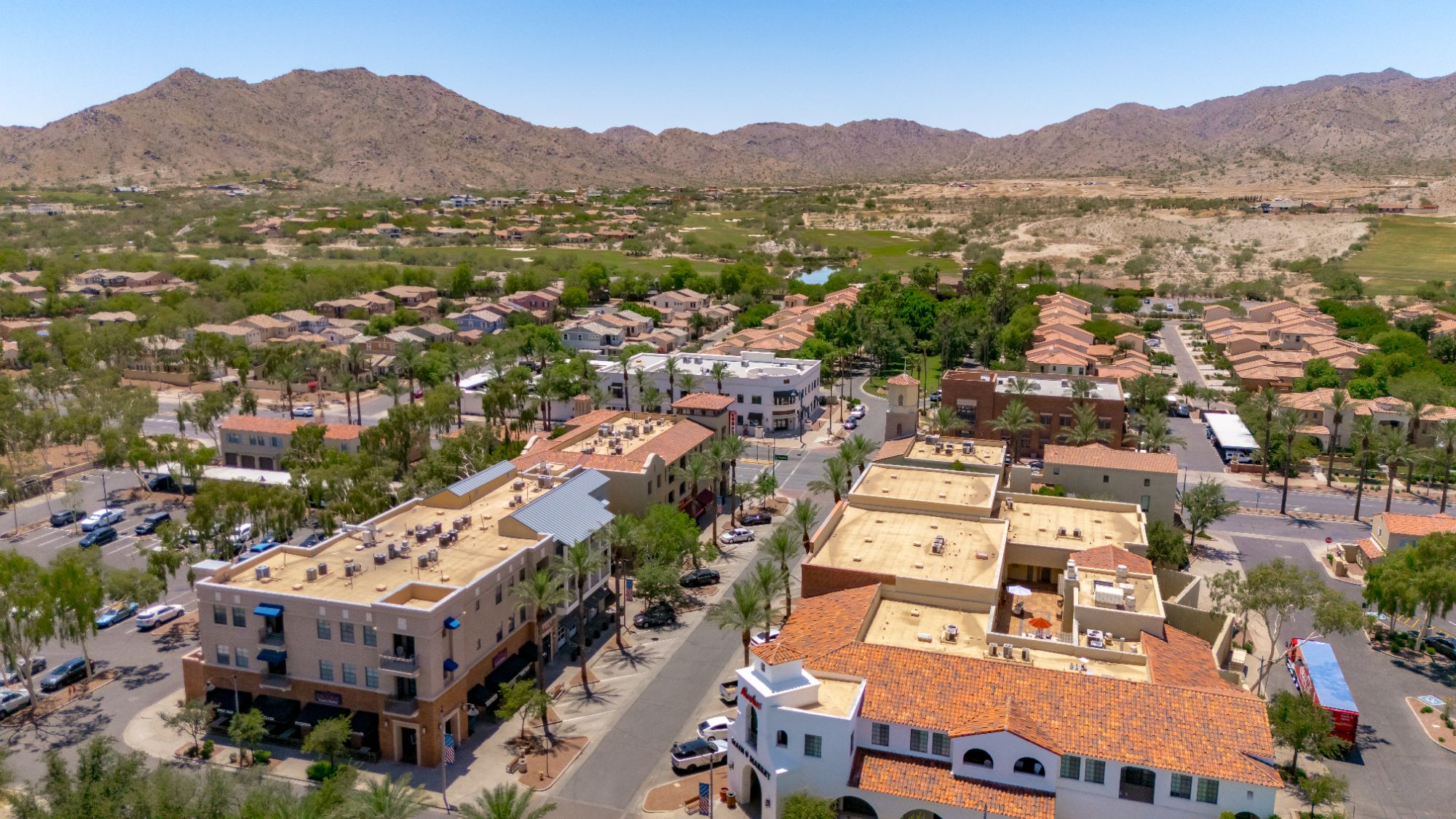 Aerial view of Verrado Main Street in Buckeye, Arizona, showcasing shops, homes, and mountain views — a vibrant West Valley community highlighted in Phoenix’s 2025 affordable neighborhoods guide.