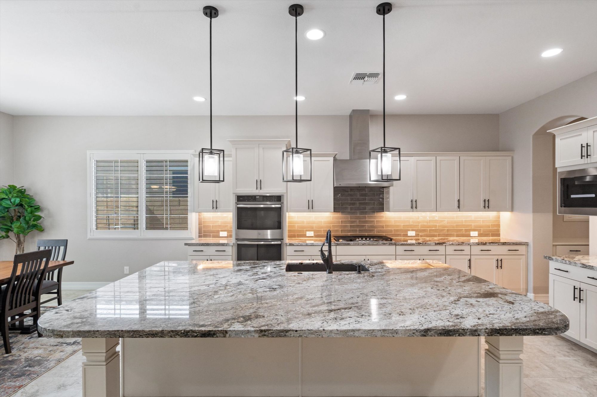 Kitchen island with pendant lighting and granite counters