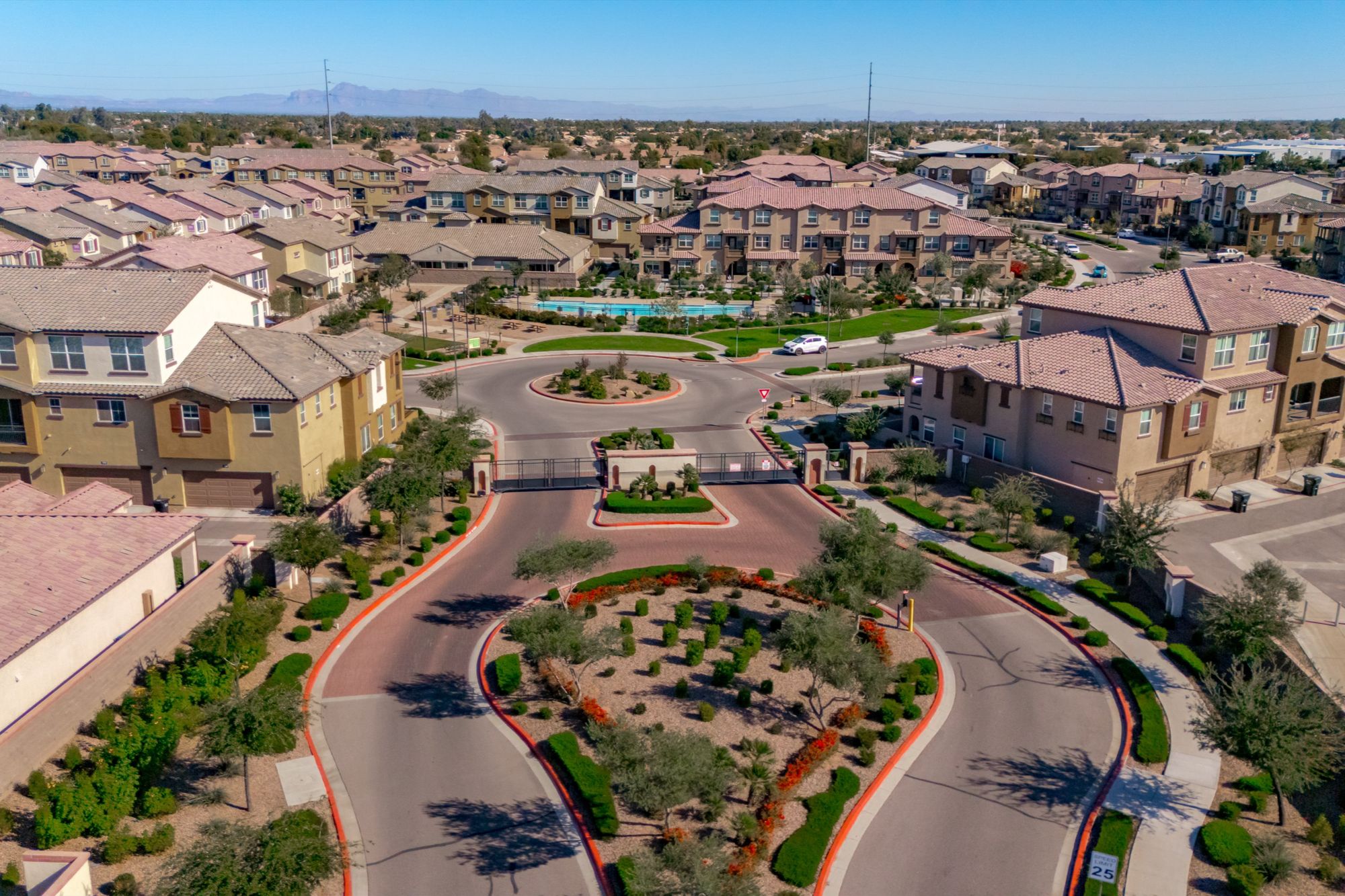 Aerial view of a gated residential community in central Chandler, Arizona, featuring modern townhomes, landscaped entry, private streets, and resort-style amenities near Downtown Chandler and East Valley freeway access.