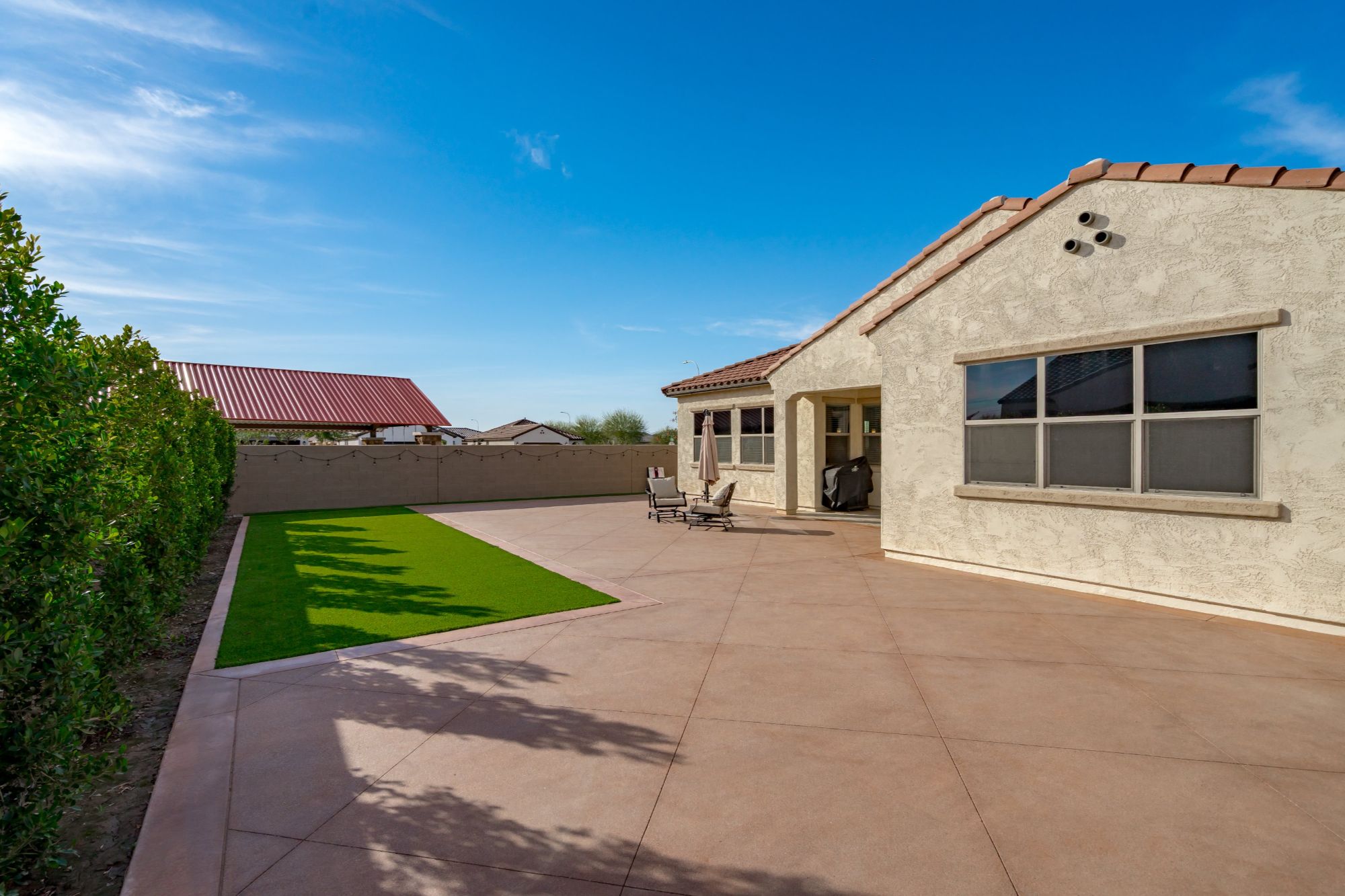 large backyard in Alamar Avondale AZ home with extended patio, low maintenance landscaping, artificial turf and space for pool and outdoor kitchen