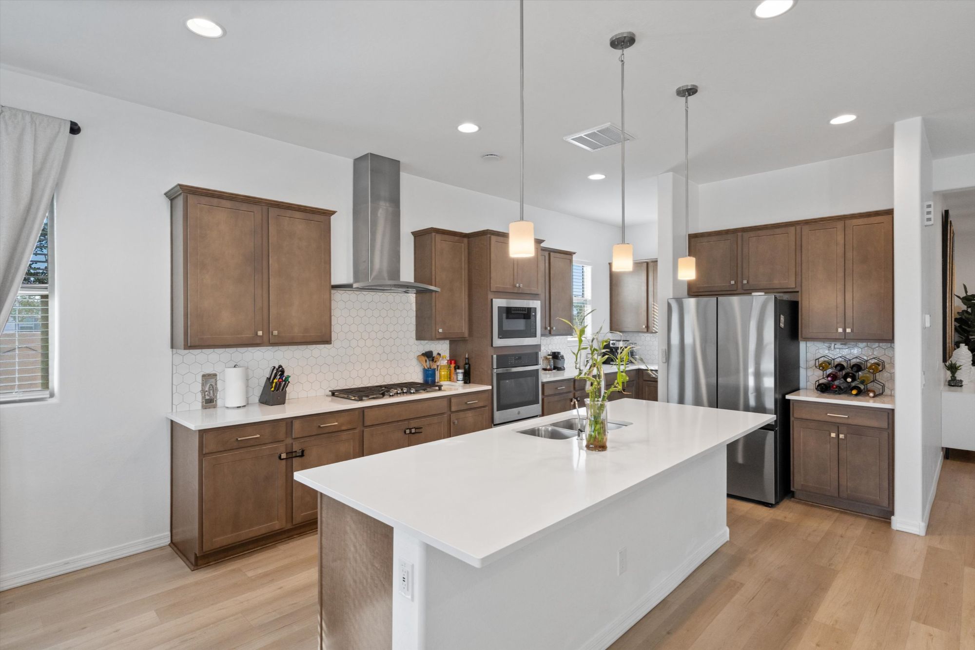 chef’s kitchen in Alamar Avondale AZ home with quartz countertops, large island, stainless steel appliances, custom cabinetry and open layout ideal for entertaining
