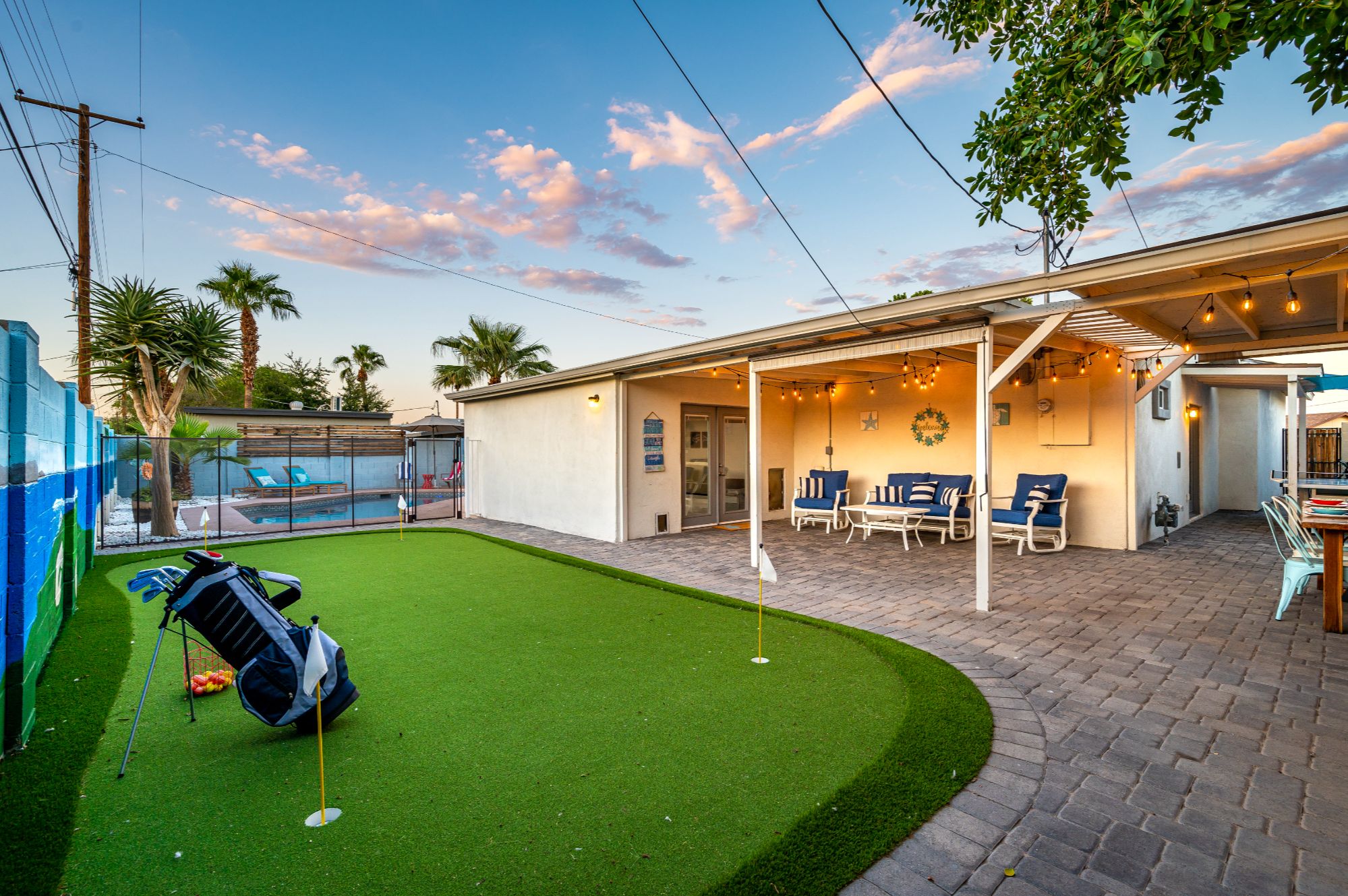 Scottsdale backyard oasis with putting green, covered patio, outdoor seating, and private pool area, designed for entertaining and maximizing short-term rental guest experience near Old Town Scottsdale