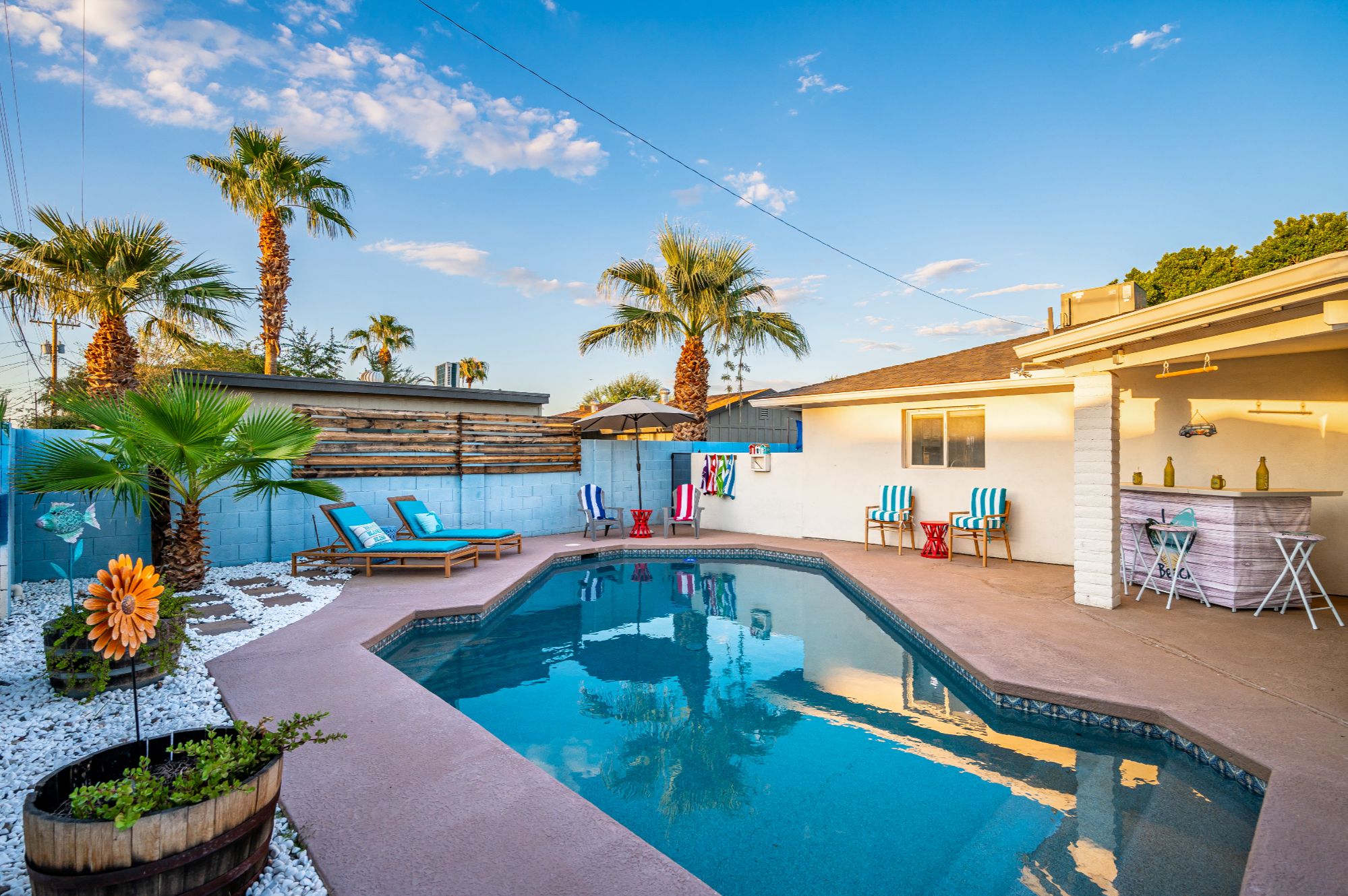 Fully renovated Scottsdale pool home near Old Town with resort-style backyard featuring private swimming pool, outdoor bar, covered patio, and palm trees, ideal for short-term rental investment or vacation home in Scottsdale Arizona
