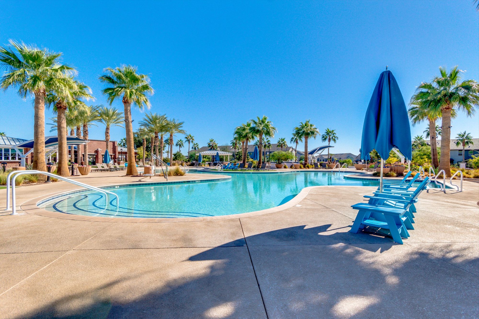 Resort-style community pool and palm-lined amenities in the Verrado master-planned community in Buckeye AZ, highlighting the lifestyle, recreation, and neighborhood amenities that attract buyers to Verrado real estate.