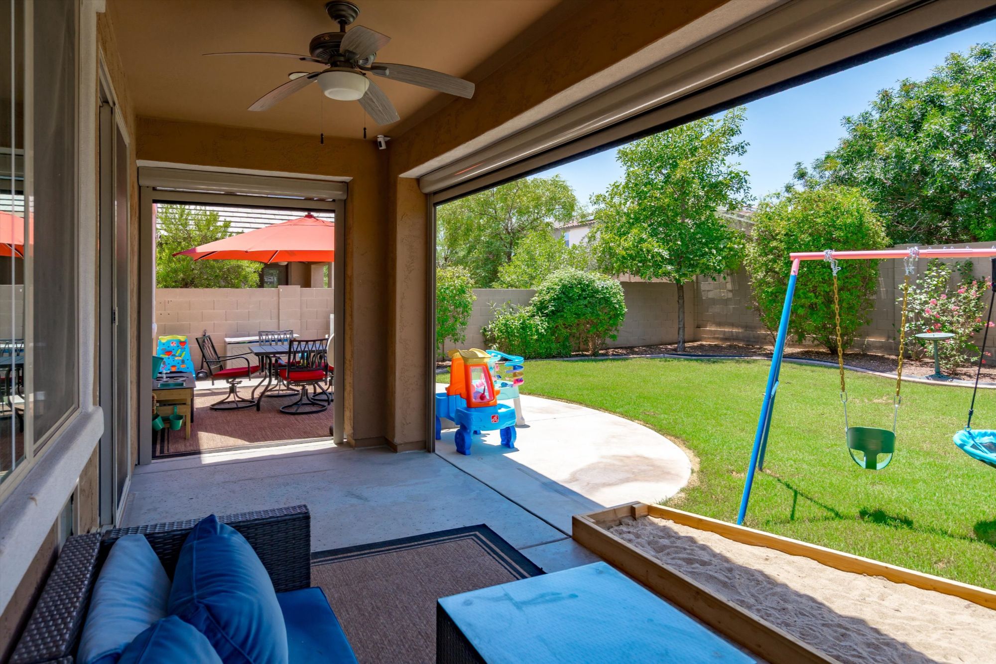 Covered patio and landscaped backyard of a Verrado Buckeye AZ home featuring outdoor living space, lawn, and family-friendly yard — highlighting the lifestyle features that help homes sell faster in the Verrado real estate market.