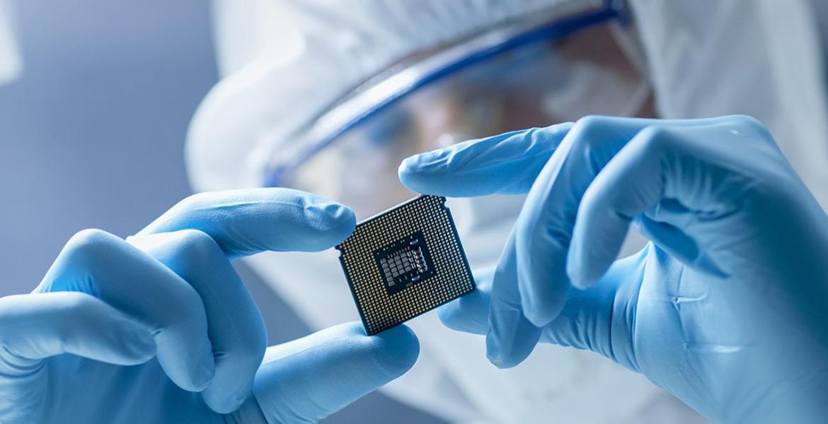 Engineer holding advanced semiconductor microchip illustrating Arizona’s growing semiconductor corridor led by Taiwan Semiconductor Manufacturing Company (TSMC) and Intel, driving technology job growth, economic expansion, and rising housing demand across the Phoenix real estate market.