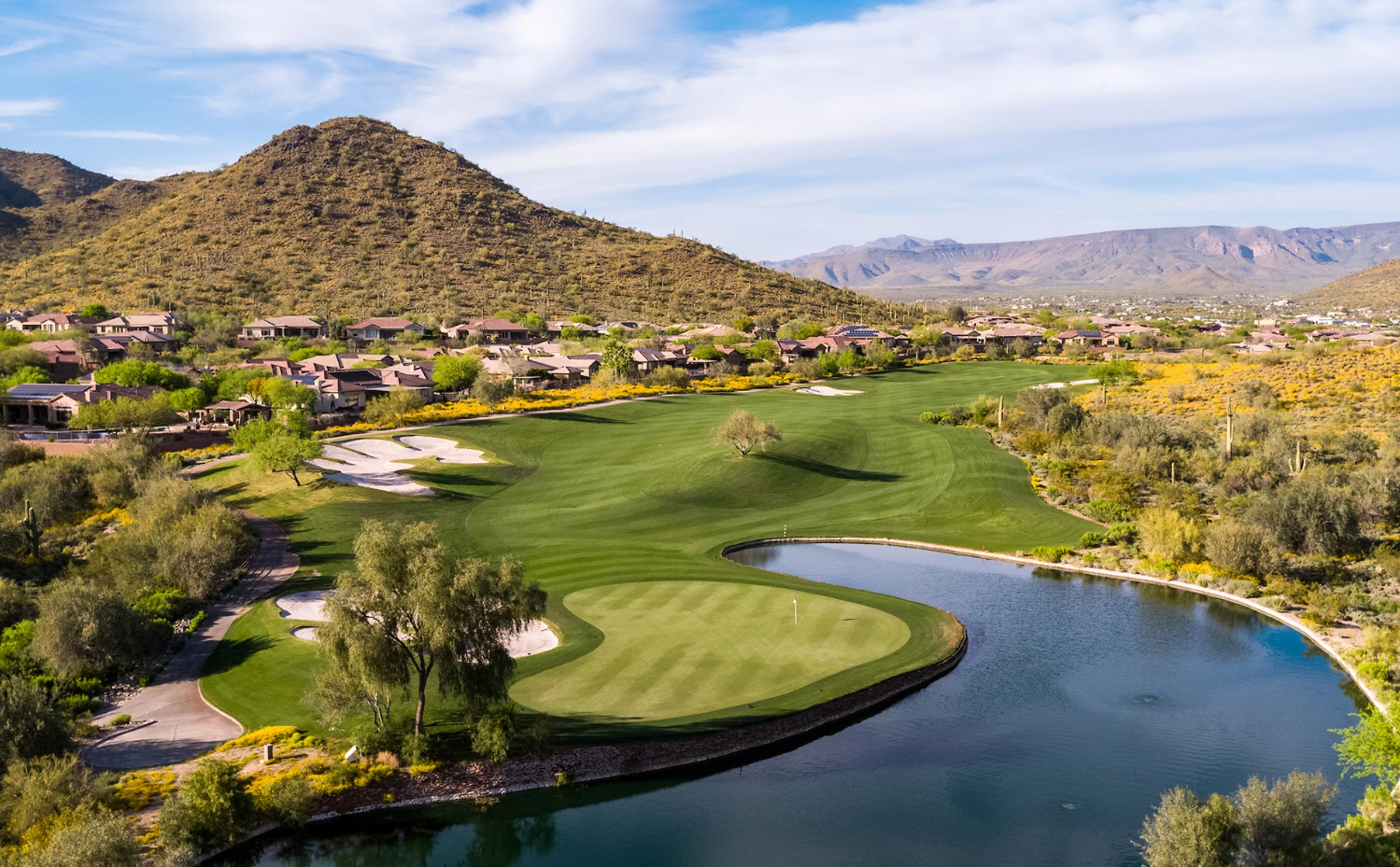 Lush golf course in the Phoenix Metro at sunrise showing green fairways framed by desert mountains