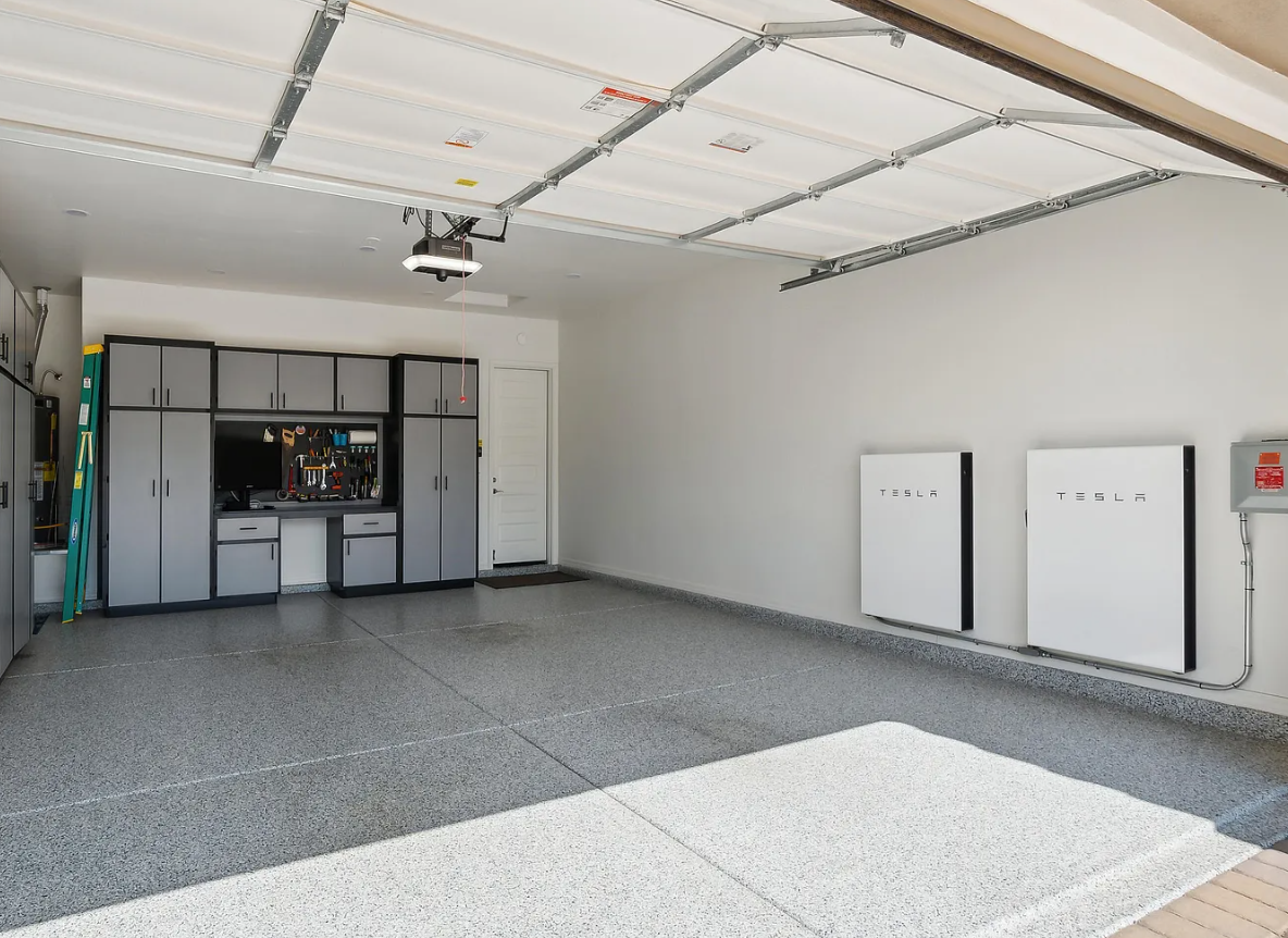 Home battery storage system mounted on a garage wall alongside solar equipment