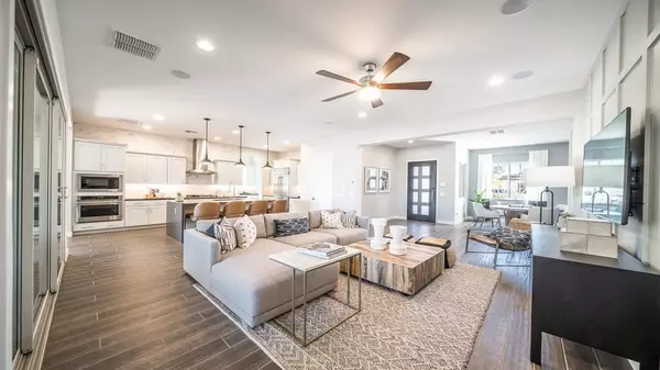 Modern open-concept living room and kitchen at CantaMia in Goodyear, AZ, showcasing vibrant community living with stylish interiors, natural light, and inviting spaces perfect for active adult lifestyles.