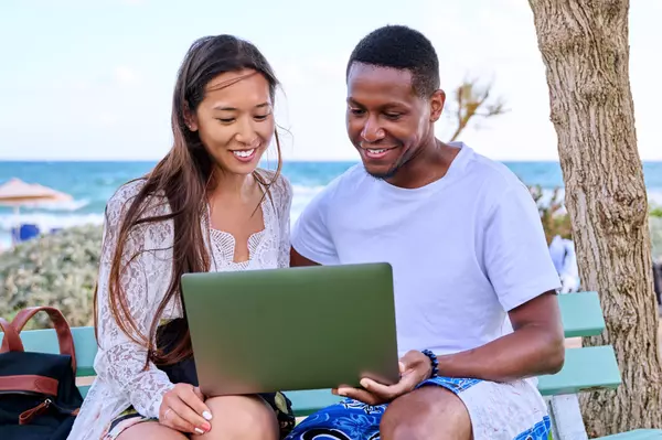 young-couple-looking-at-laptop-screen-sitting-on-2024-12-08-01-53-40-utc