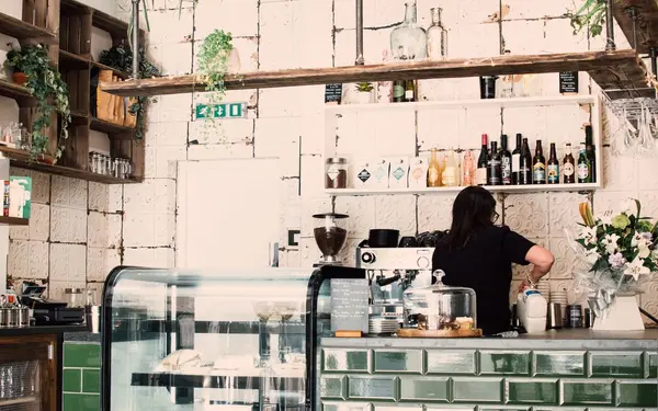 Barista preparing coffee behind the counter in a cozy cafe