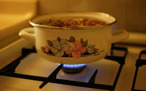 A pot simmering on a stove in a cozy kitchen