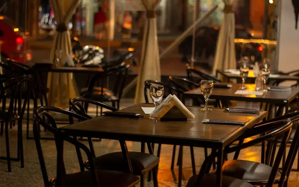 Warmly lit restaurant interior with set tables and wine glasses
