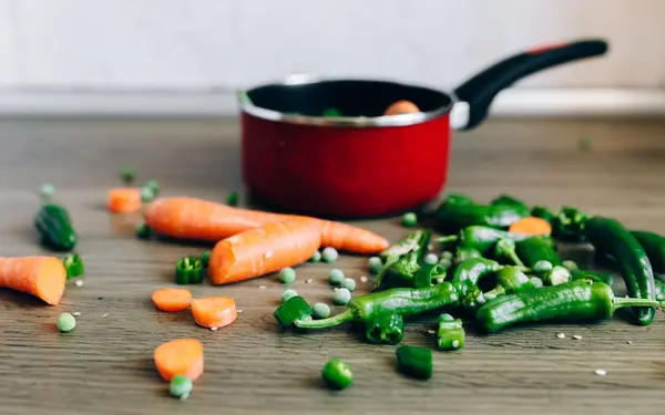 Fresh vegetables and a cooking pot on a kitchen counter