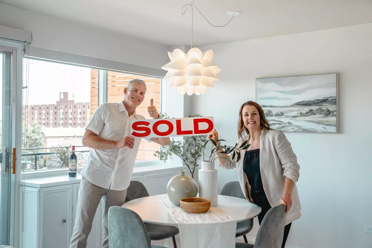 Karen and Jeff hold a SOLD sign