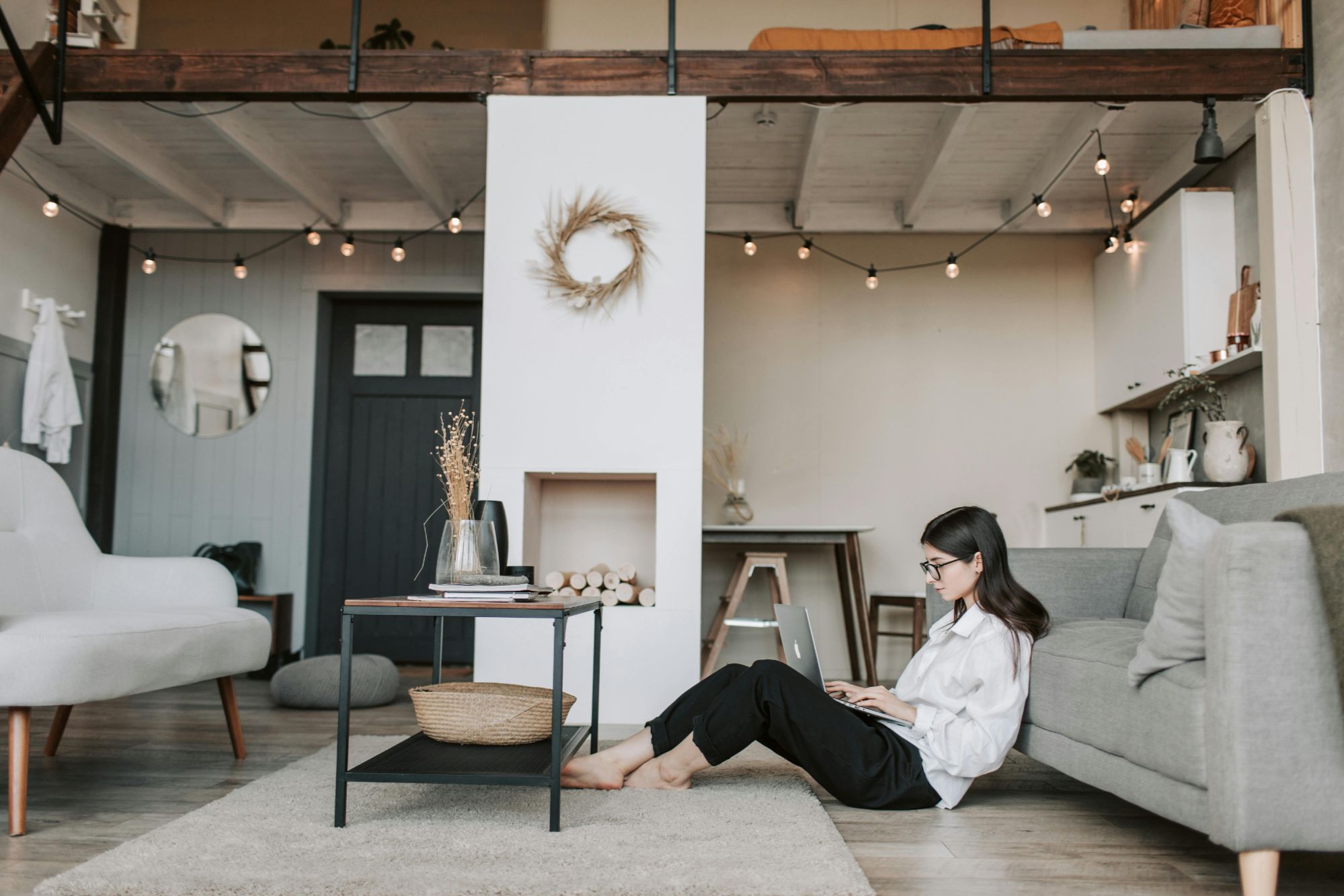 modern living room with a woman working on her laptop on the floor