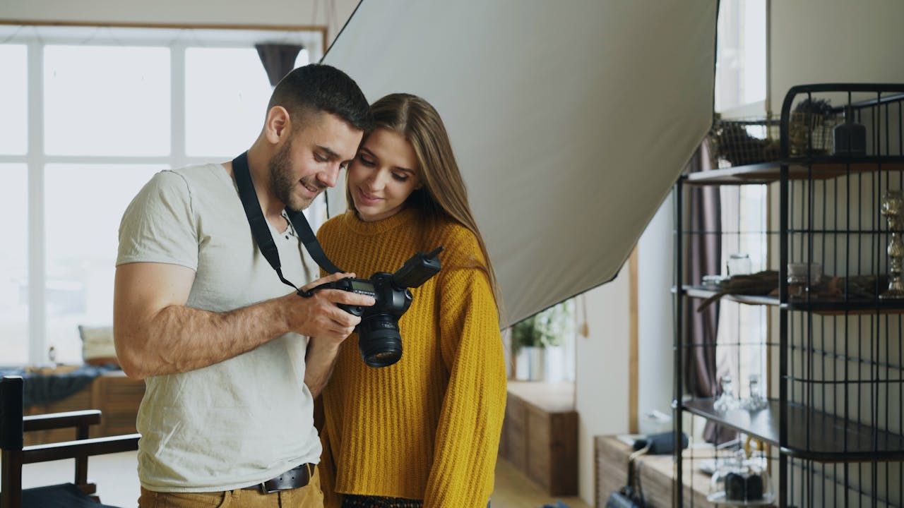 two people looking down at a camera inside a house
