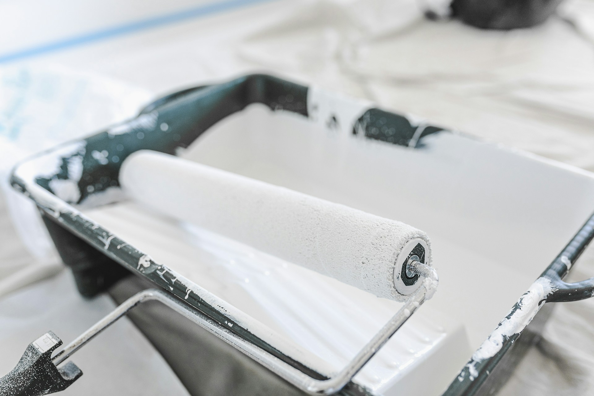 white paint in a pan and a paint roller