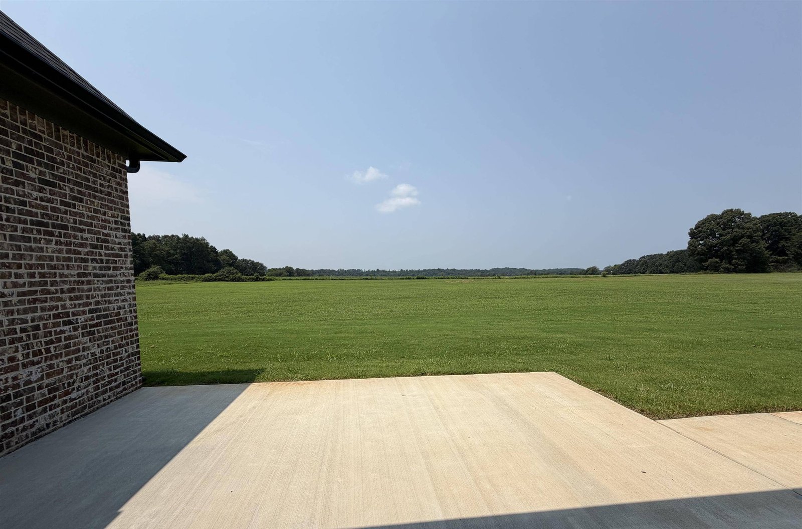 Covered patio of a new home looking out over an open acreage homesite in Sydney School Estates, Hazel Green, Alabama