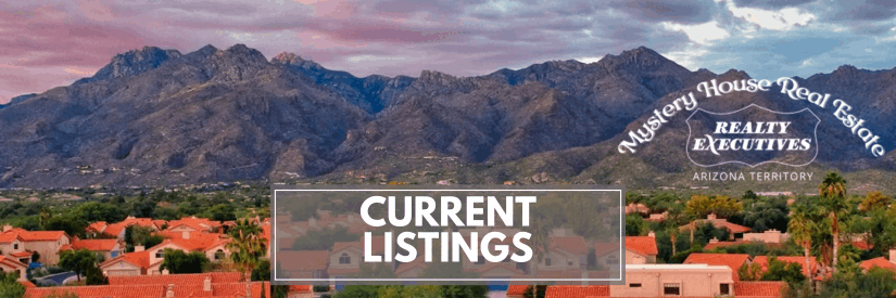Panoramic view of Tucson homes with red tile roofs in the foreground and the Catalina Mountains under a colorful sunset sky. A banner reads “Current Listings” with Mystery House Real Estate and Realty Executives Arizona Territory logos.