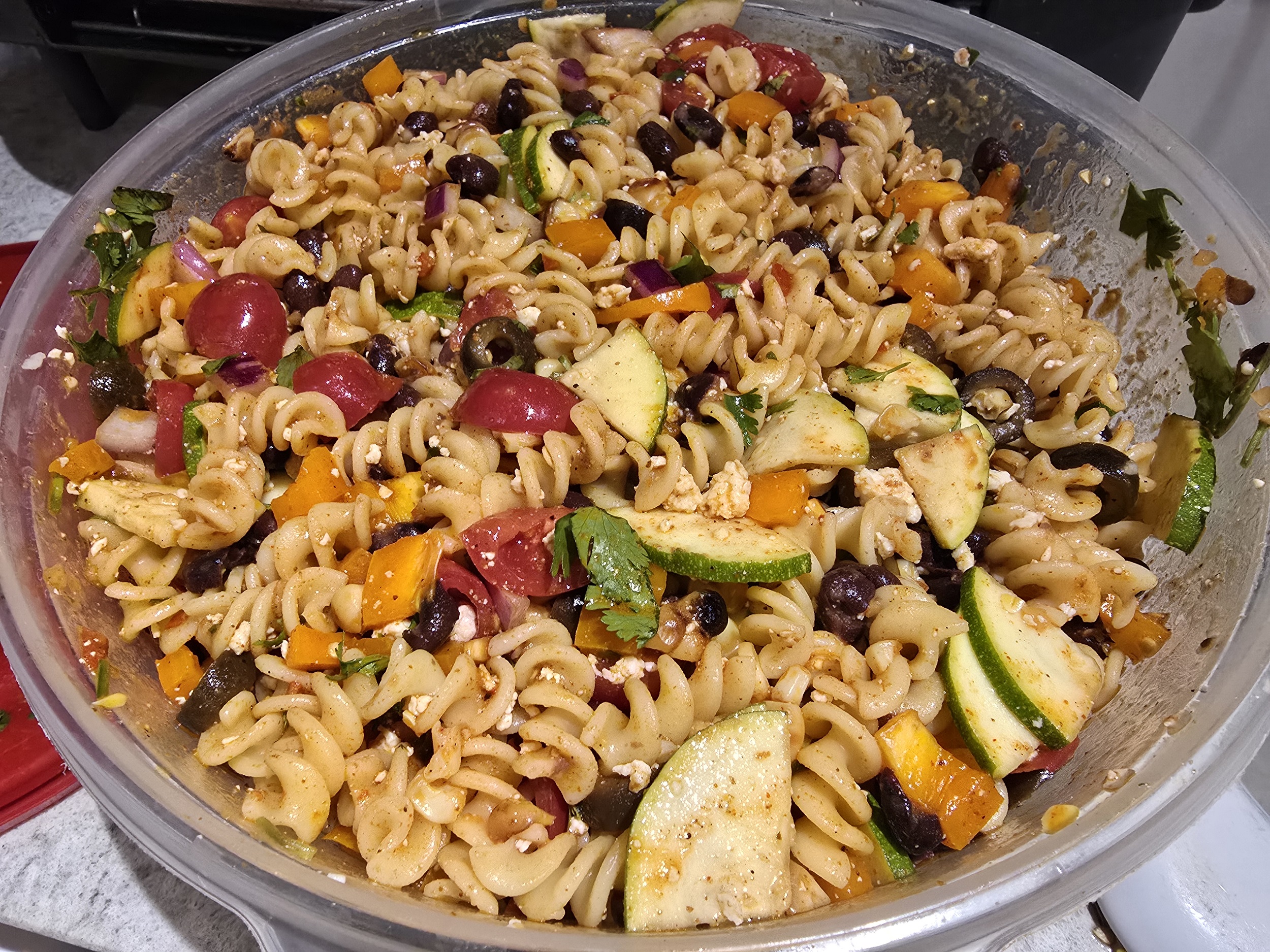 An individual serving of taco pasta salad on a plate with a lime wedge