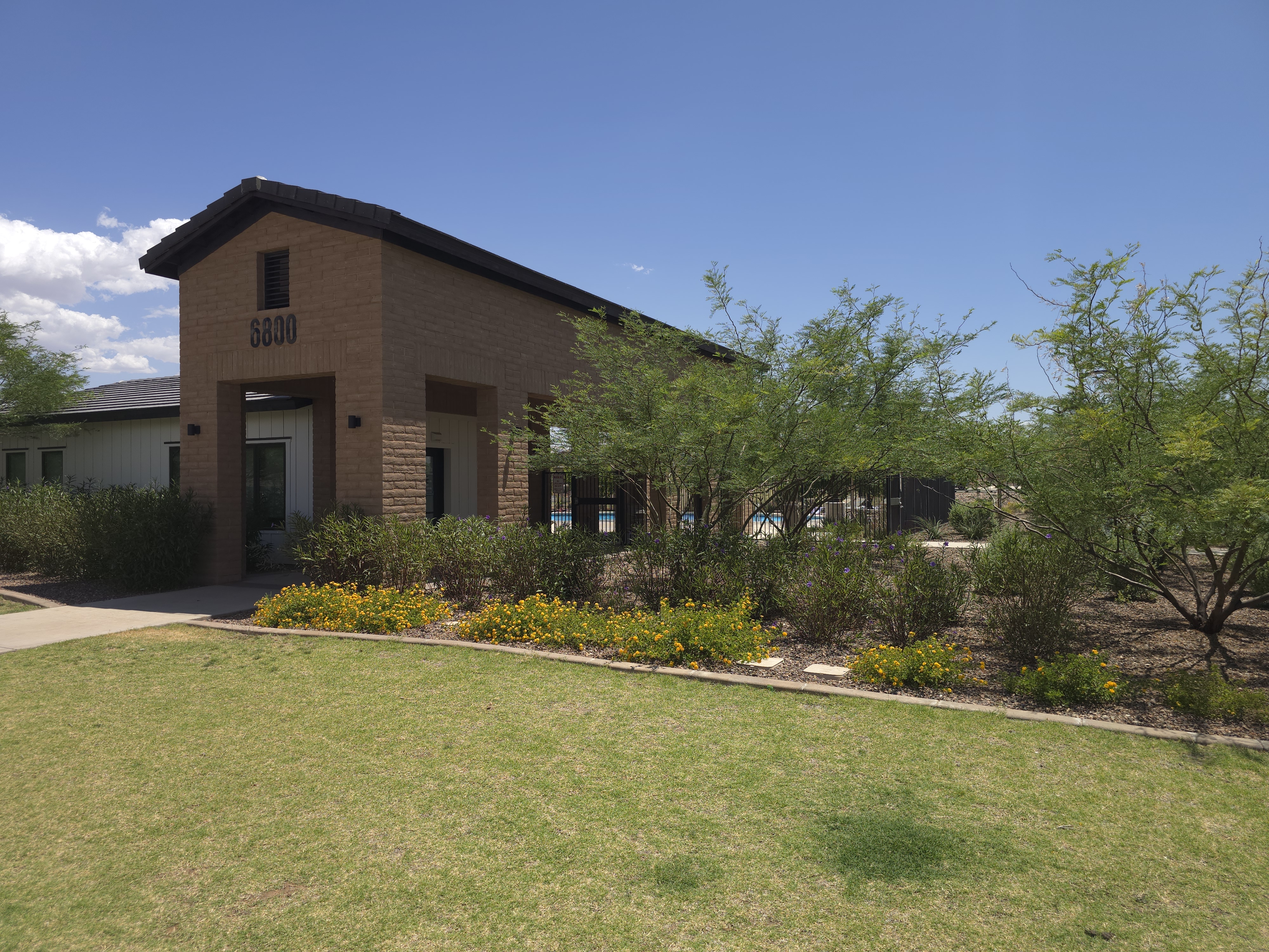 Cornerstone Park clubhouse at 6800 E Camino Agua Limpia in La Estancia de Tucson, with the community pool visible behind a wrought iron gate