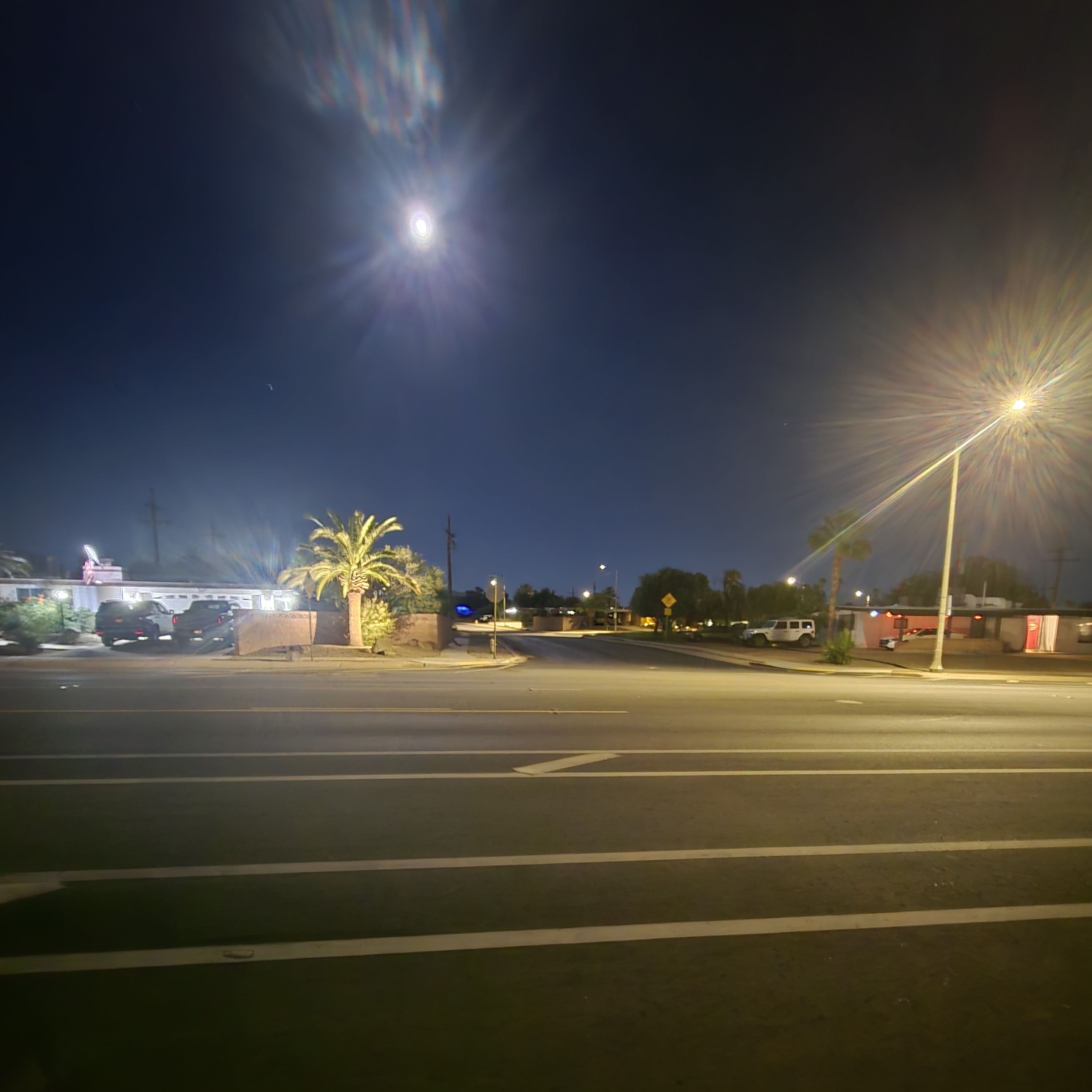 A residential street seen from a slowly moving car at dusk
