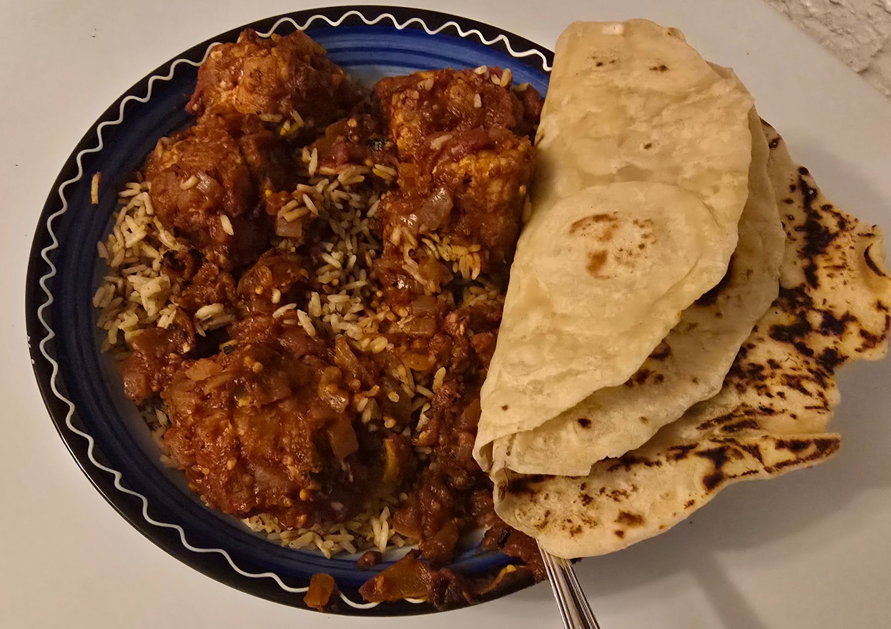 A plated serving of chipotle chicken meatballs with rice, crema, and queso fresco