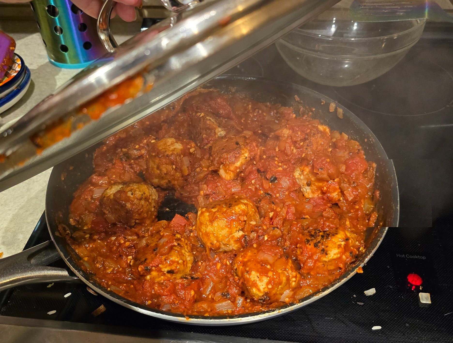 Skillet of ground chicken meatballs simmering in chipotle-tomato sauce