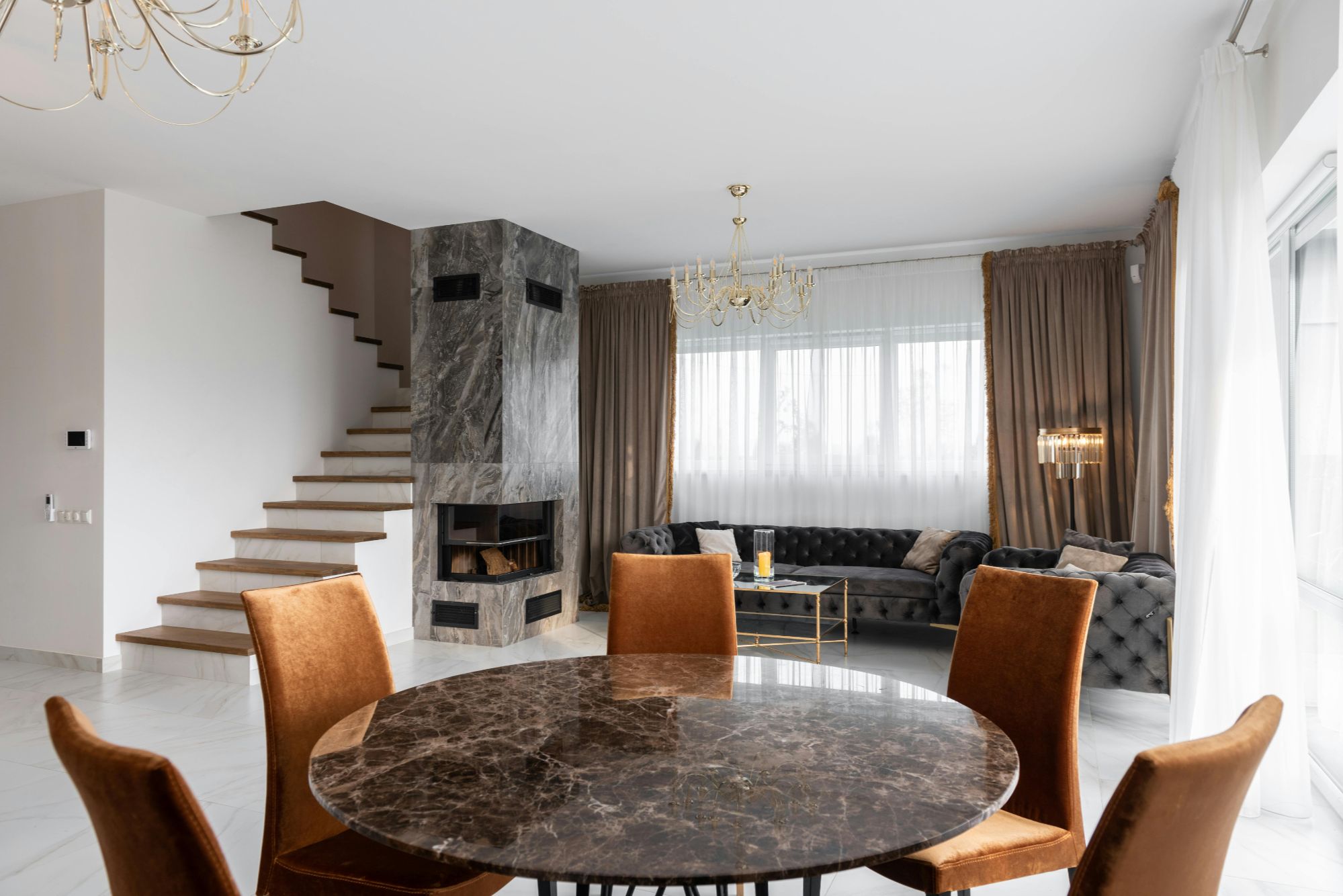 Sala de estar moderna con chimenea de mármol y mobiliario contemporáneo