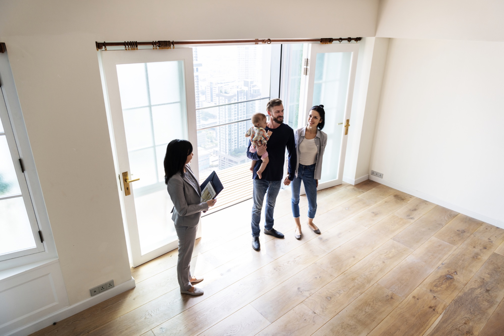 Couple with child touring a home with a realtor