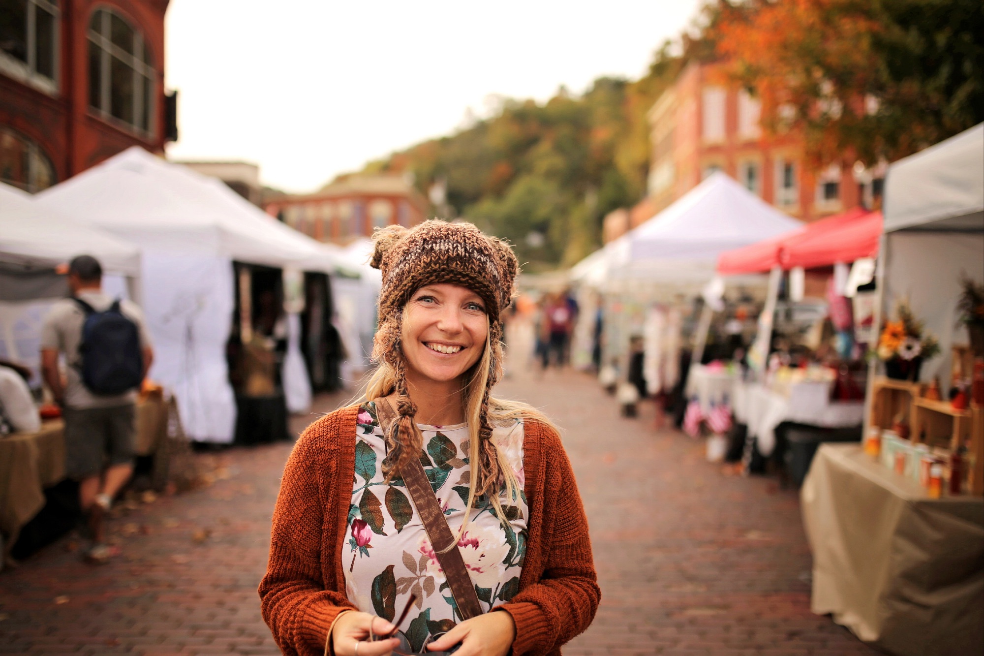 Happy Woman Smiling in Hand Knit Hat at Fall Festival Outside.