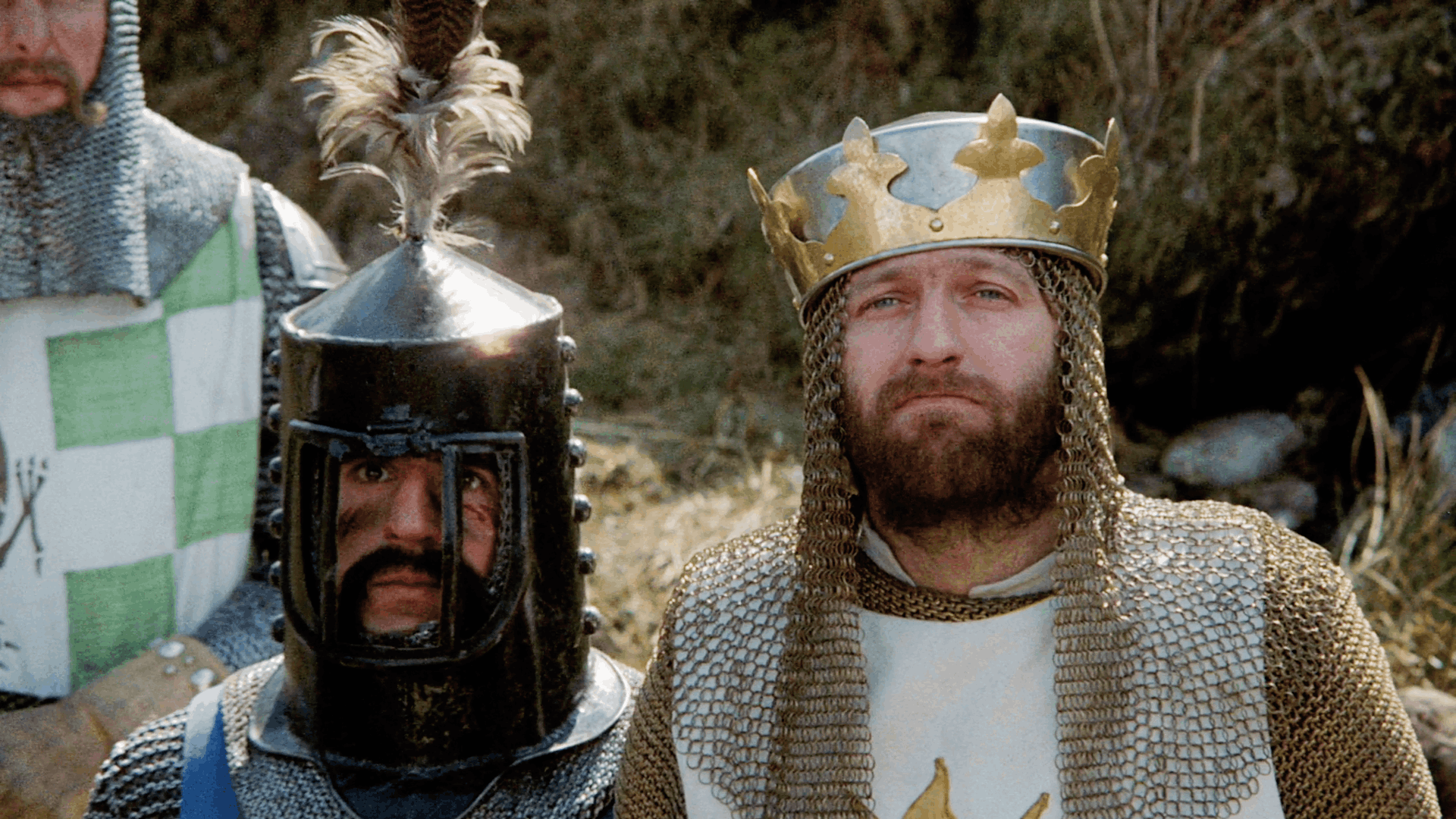 Two knights from Monty Python and the Holy Grail, one wearing a gold crown and chainmail, the other in a black helmet with a feather, staring seriously into the distance — the perfect facial expression for discovering a move-in ready home in Yukon, OK.