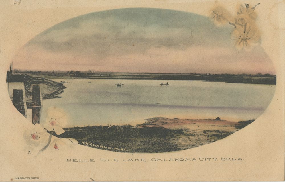 Hand-colored Belle Isle Lake postcard showing boats, shoreline and a floral border in early Oklahoma City.