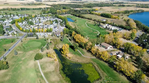 Aerial view of Gleniffer Lake Resort and Country Club in Central Alberta showing the golf course, surrounding recreational community, RV sites and nearby lake landscape.
