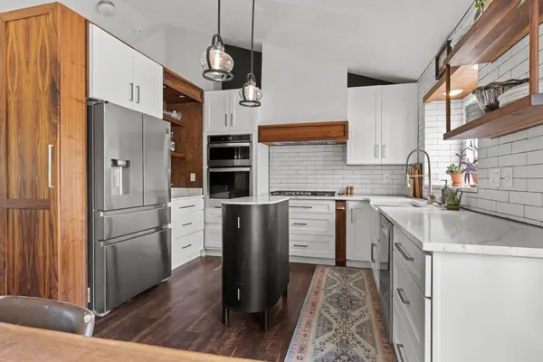 Inspiration board worthy kitchen with plaster & wood vent hood, floating shelves and pull out spice racks.  