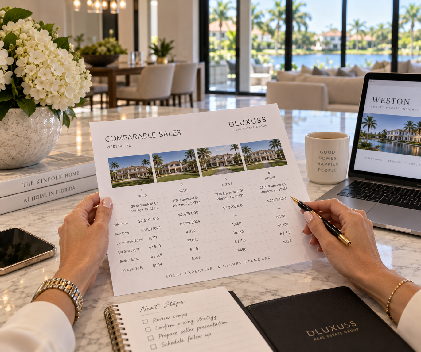 Hands reviewing a printed comparable sales sheet on a bright kitchen island.