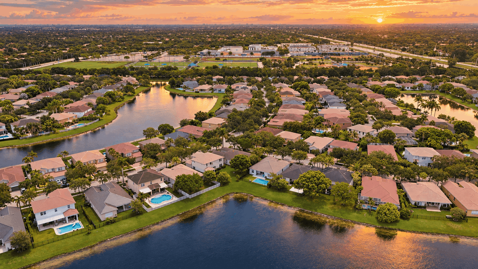 Aerial view of South Florida suburban communities at golden hour representing the August 2026 luxury market report