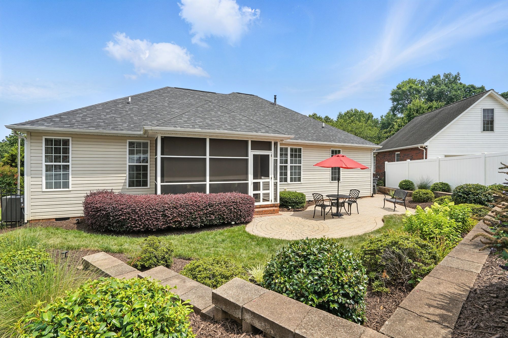 Beautifully landscaped backyard with screened porch and paver patio at 2300 Wednesbury Ct Kannapolis NC