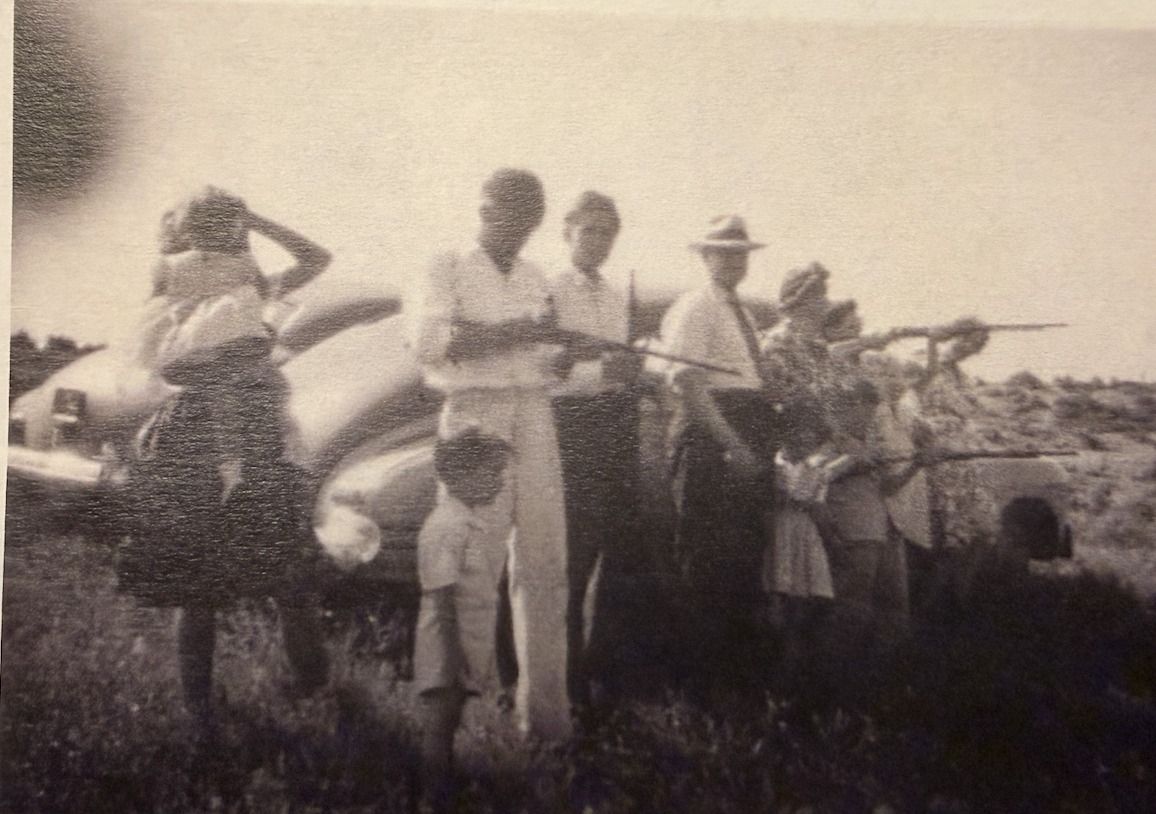 The Holbrook family lined up by the Jordan River in Lehi in 1944, shooting .22s at tin cans