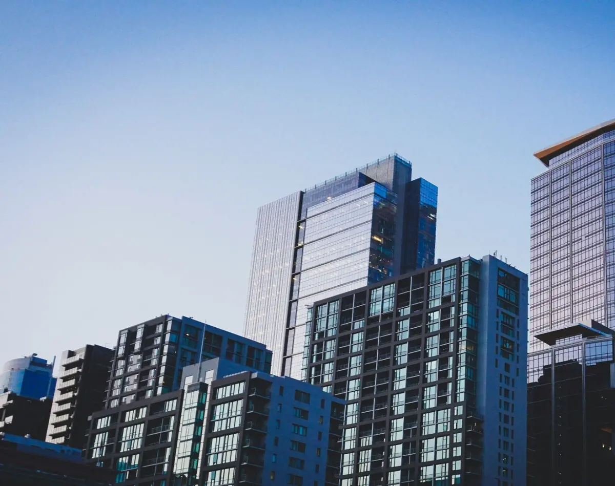 White and blue glass condo buildings. Photo by Jason Dent on Unsplash