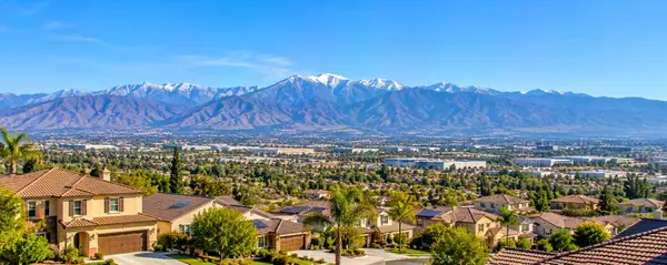 Suburban Valley Beneath Snowy Peaks