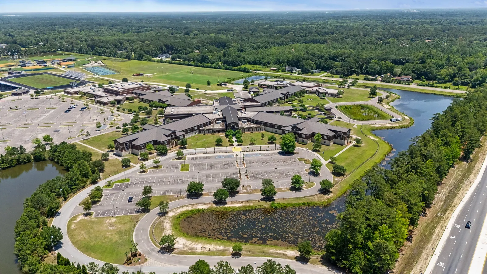 Aerial view of Cane Bay Elementary Middle and High School campus in Summerville SC with athletic fields and ponds