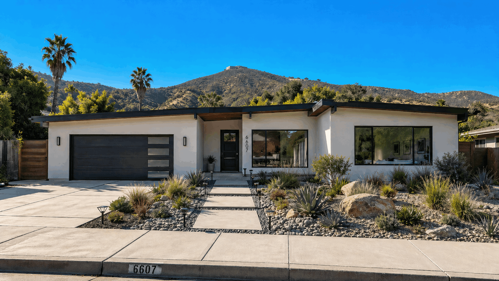 Renovated white mid-century modern ranch house with black trim and xeriscaped yard in San Carlos, San Diego.
