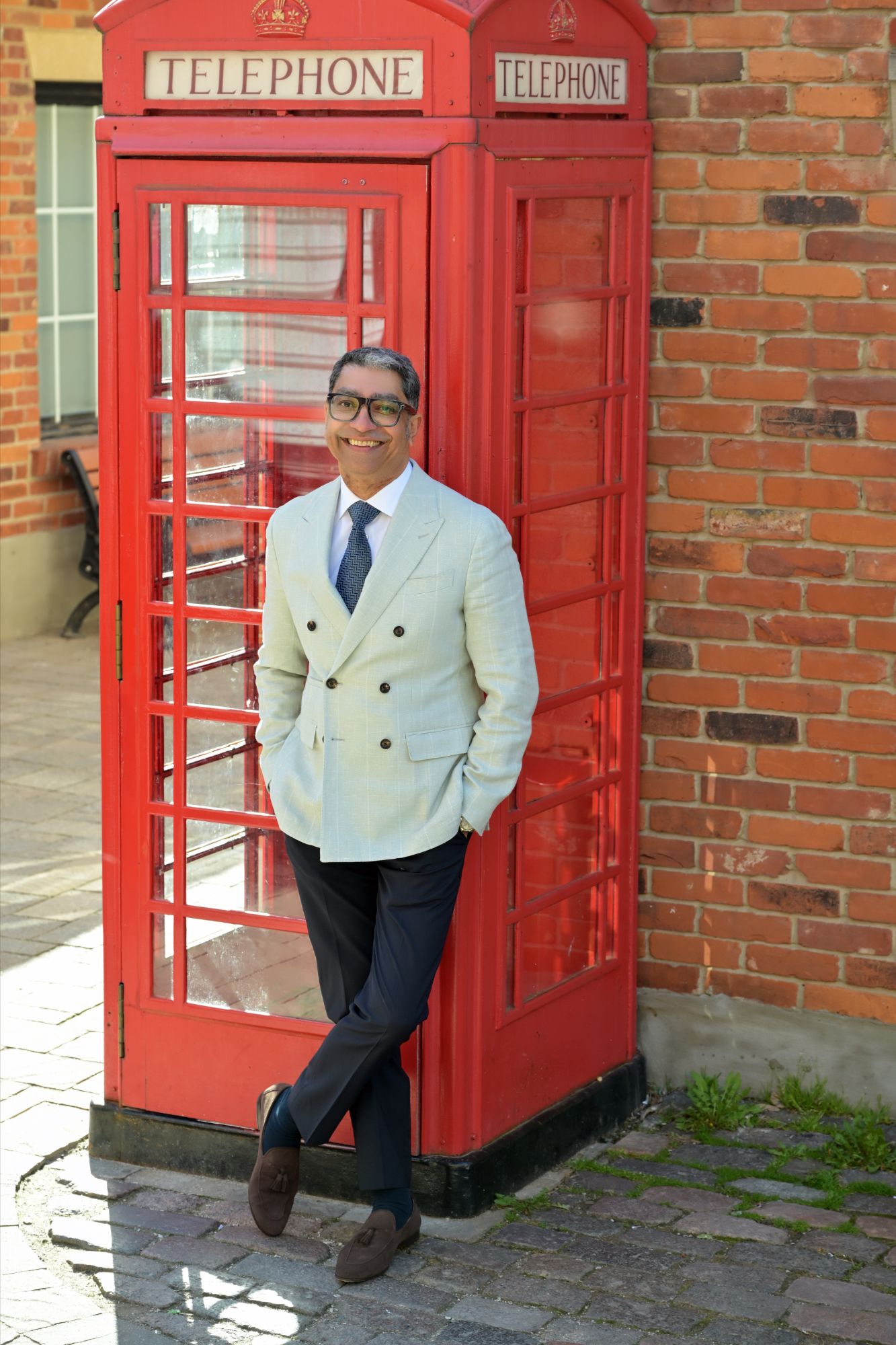 Neesh Buttoo beside a red English telephone box