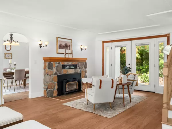 Bright living room with updated LVP flooring and cozy Tudor character – Gatz Home Group.