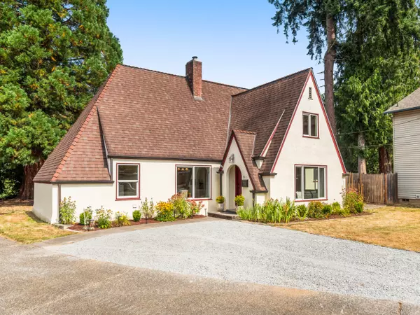 Charming Tudor-style home in Arlington WA with brick accents, steep gables, and mature landscaping – listed by Gatz Home Group.