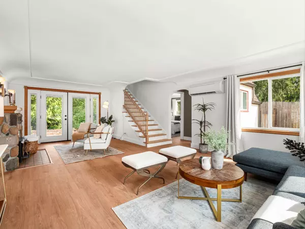 Bright living room with updated LVP flooring and cozy Tudor character – Gatz Home Group.