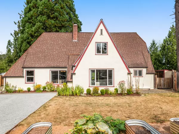 Charming Tudor-style home in Arlington WA with brick accents, steep gables, and mature landscaping – listed by Gatz Home Group.